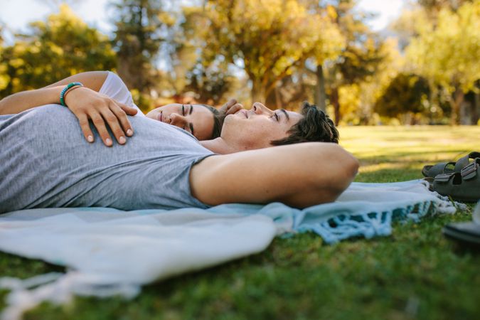 Couple relaxing in a park lying on the ground