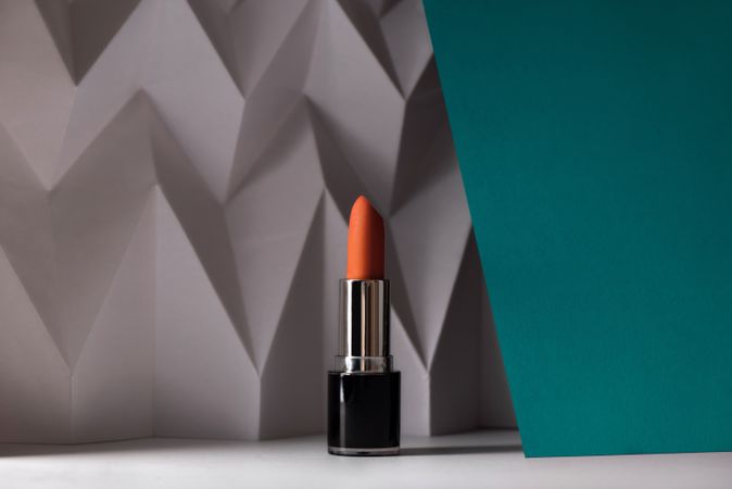 Pink lipstick on raised chevron. Product and make up contemporary concept