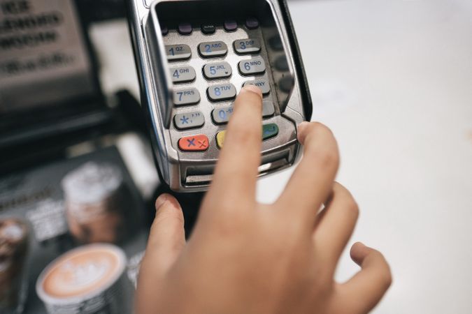 Close up of hand touching  credit card machine