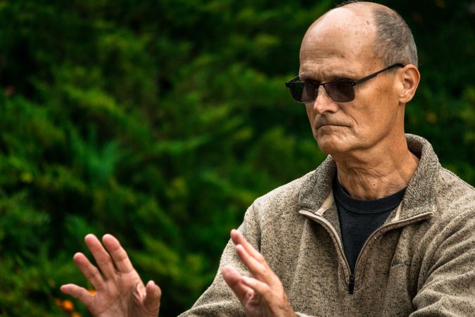 Older man practicing martial arts in countryside