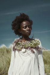 Young woman pink dress with wreath on shoulders standing outdoor