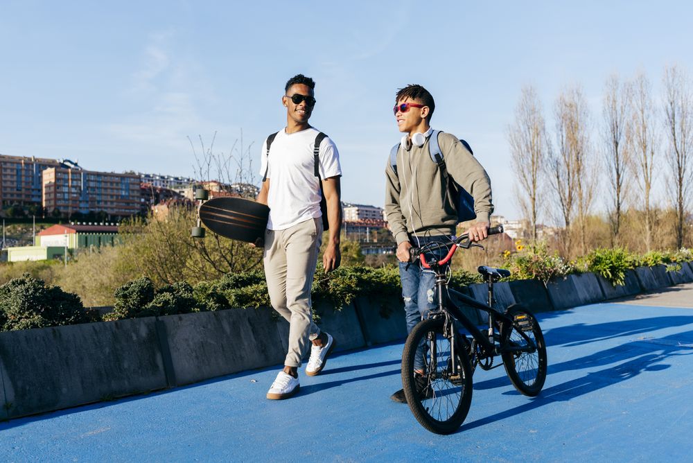 Young Black happy male friends walking in city