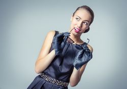 Vintage fashion model holding sunglasses to mouth