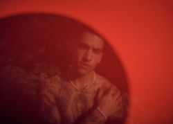 Man seen behind red sheet