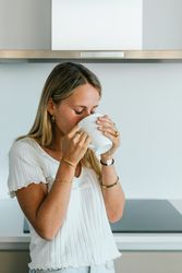 Woman drinking coffee in kitchen