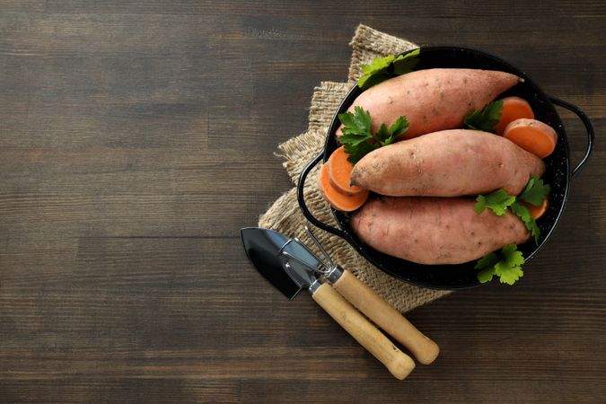 Fresh sliced sweet potato on wooden background