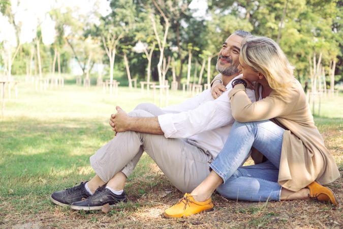 Content couple sitting on the grass in a park