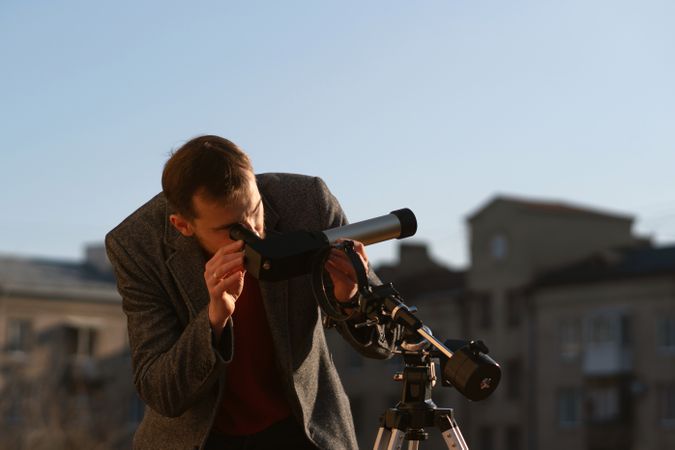 Astronomer examines the sun using a specialized telescope on rooftop