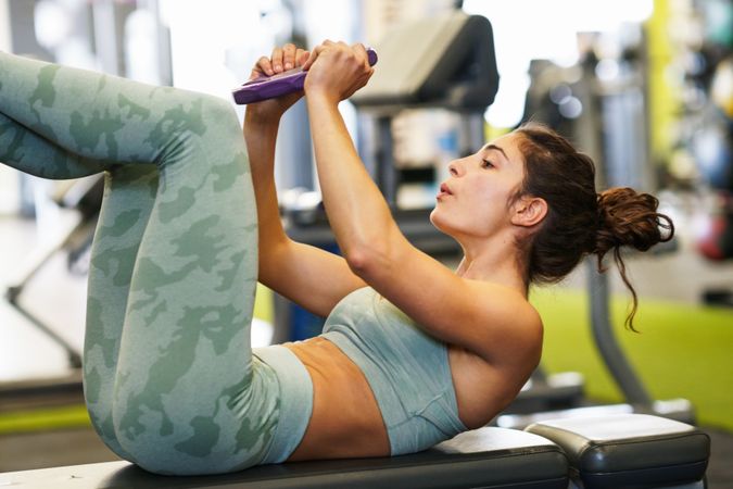 Woman exercising her abs in gym on mat