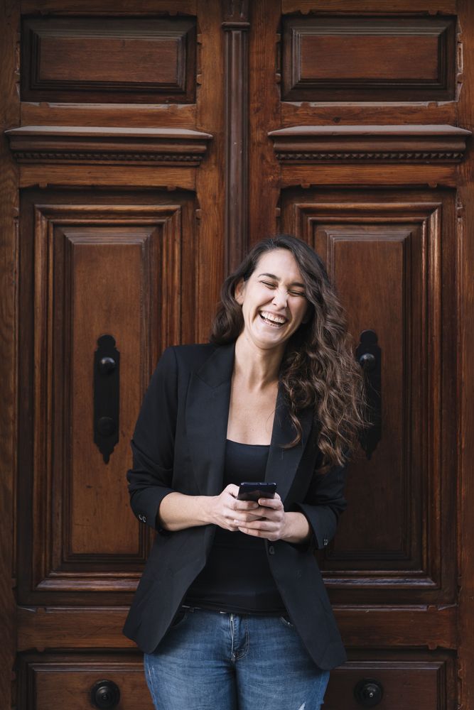 Young female using mobile phone on wooden door