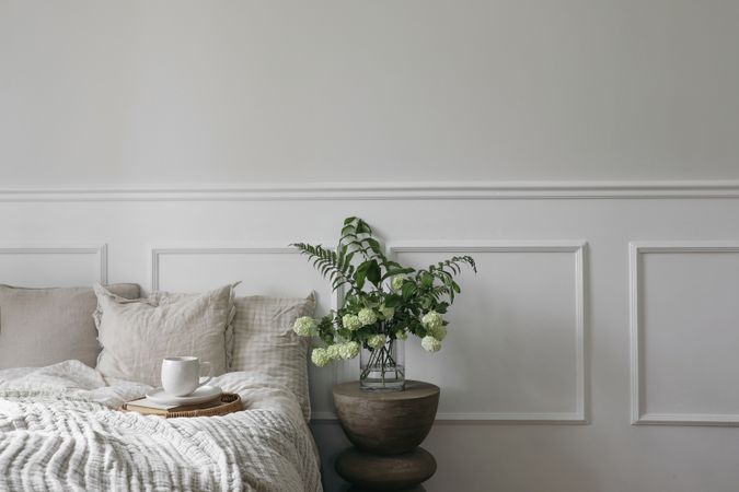Bed with tray of coffee and vase with flowers