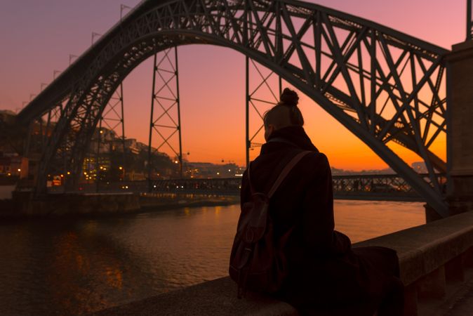 Woman looking at river and city in evening