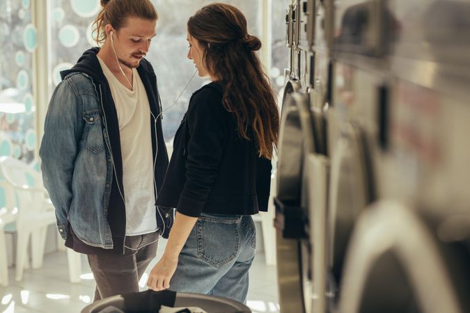 Dating couple enjoying music together at laundromat