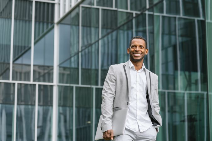 Black man holding laptop on street