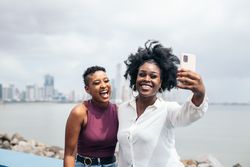 Stylish friends taking selfies along the boardwalk in Panama City