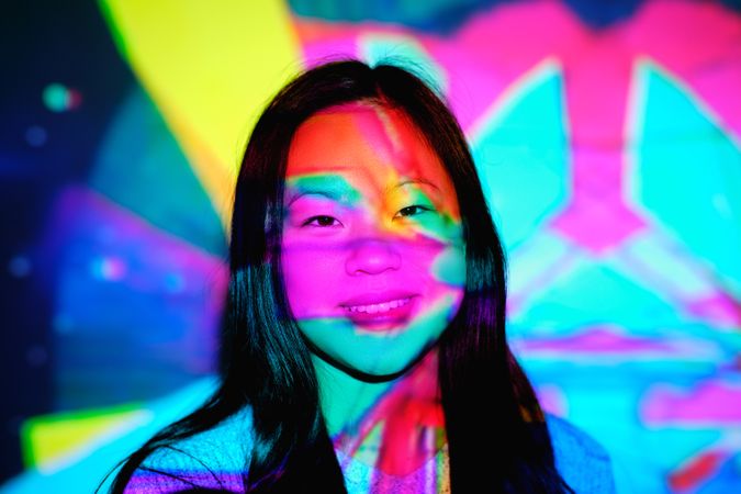 Smiling Asian woman under colorful lights