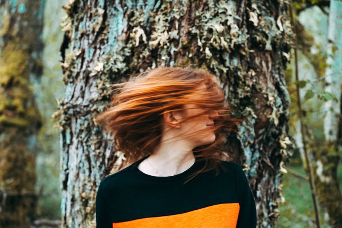 Casual redhead woman shaking with hair