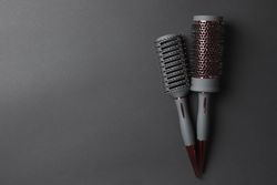 Hair brushes on dark background, space for text