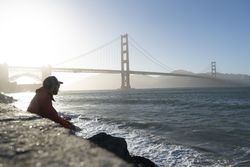 Tourist gazing at scenic bridge at peaceful bay