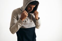 Serious Black man wearing hood with his head down