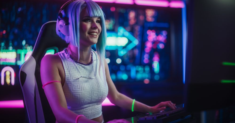 Stylish Streamer or Gamer with Blue Hair Chats with Internet Fans on Computer in Futuristic Cyber Technology Room.