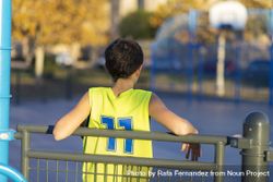 Back of young male teen wearing a yellow basketball sleeveless smiling 4dOGA5