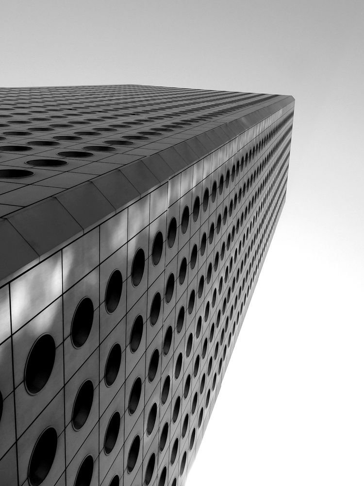Low-angle view of a skyscraper in grayscale