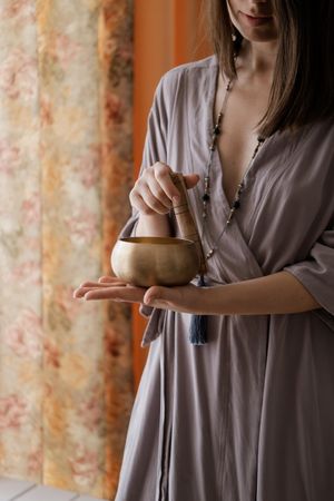 Woman in blue dress holding a golden pot