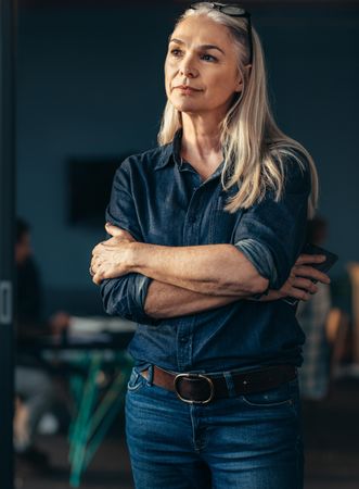 Portrait of tech executive  standing in office with her arms crossed looking away