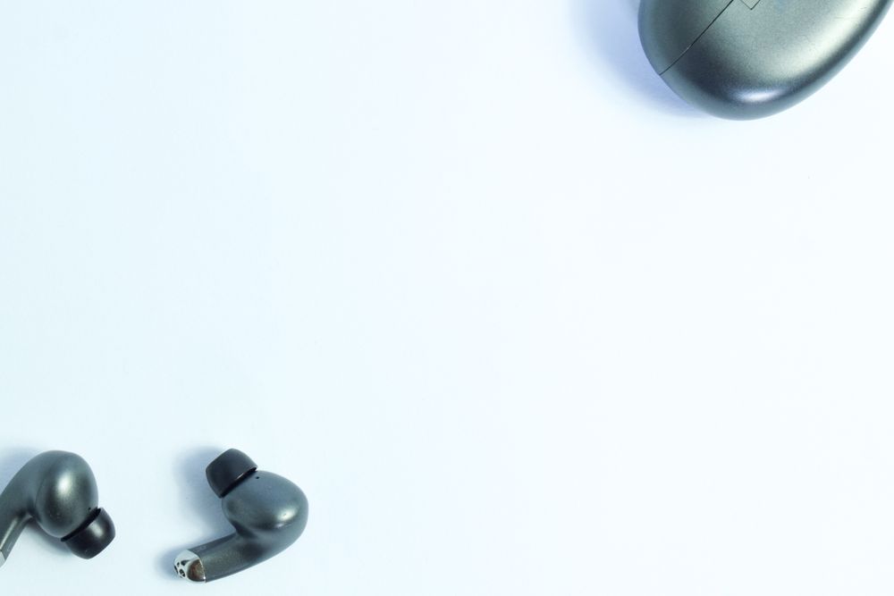 Top view of wireless earbuds on plain table with space for text