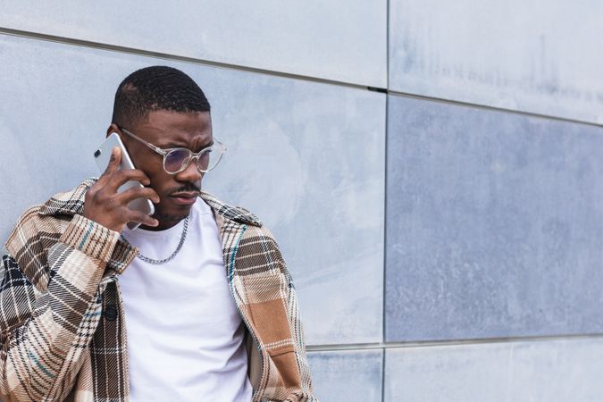 Stylish Black male using smartphone on street