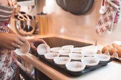Cropped image of woman preparing paper cups for muffins
