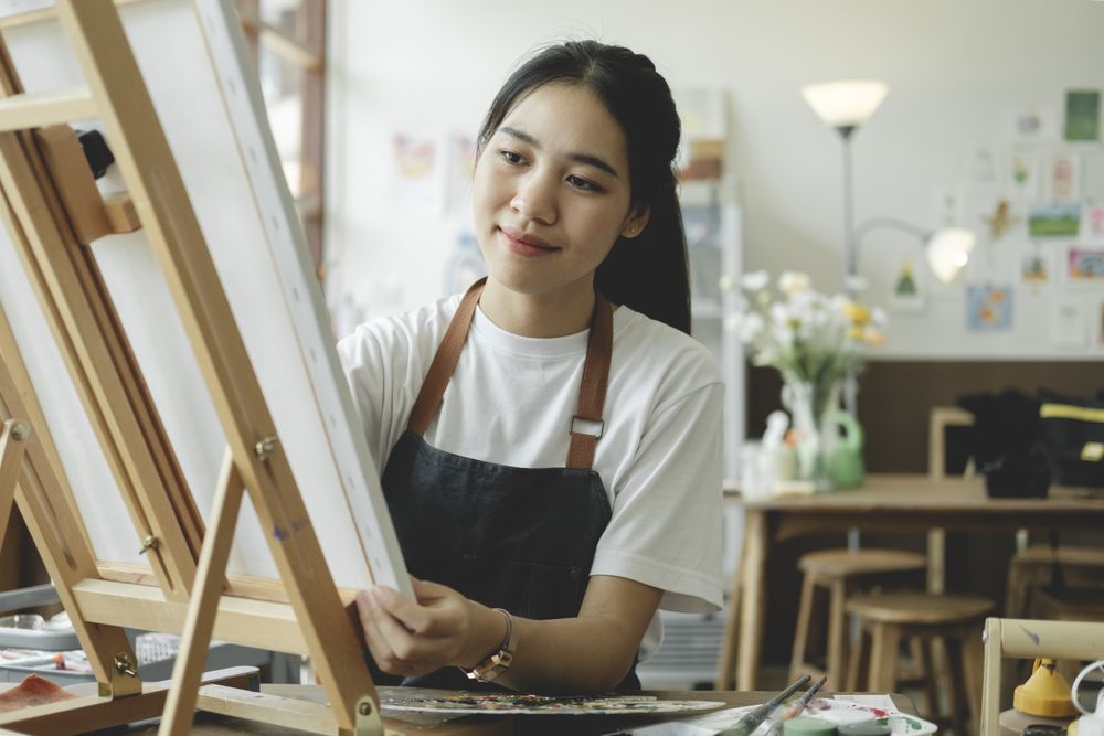 Crafting Inspiration. Female Artist Sketching and Painting in Workshop