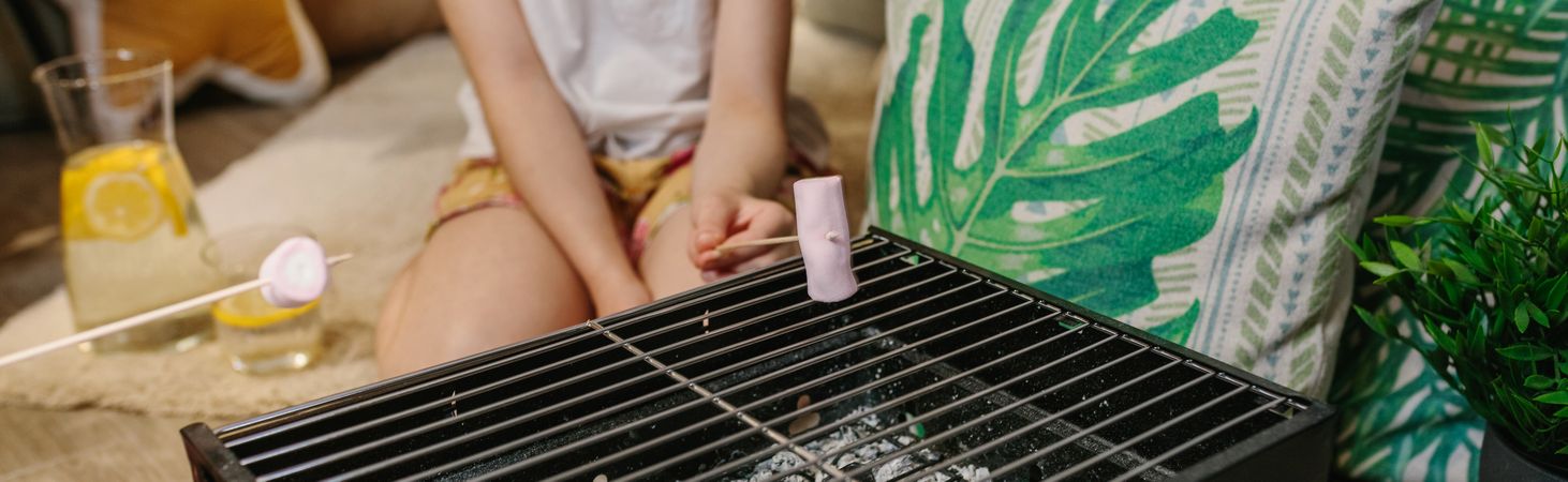 Girl camping at home roasting marshmallows