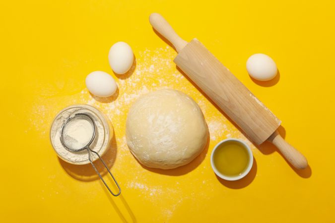 Concept for baking with dough on yellow background