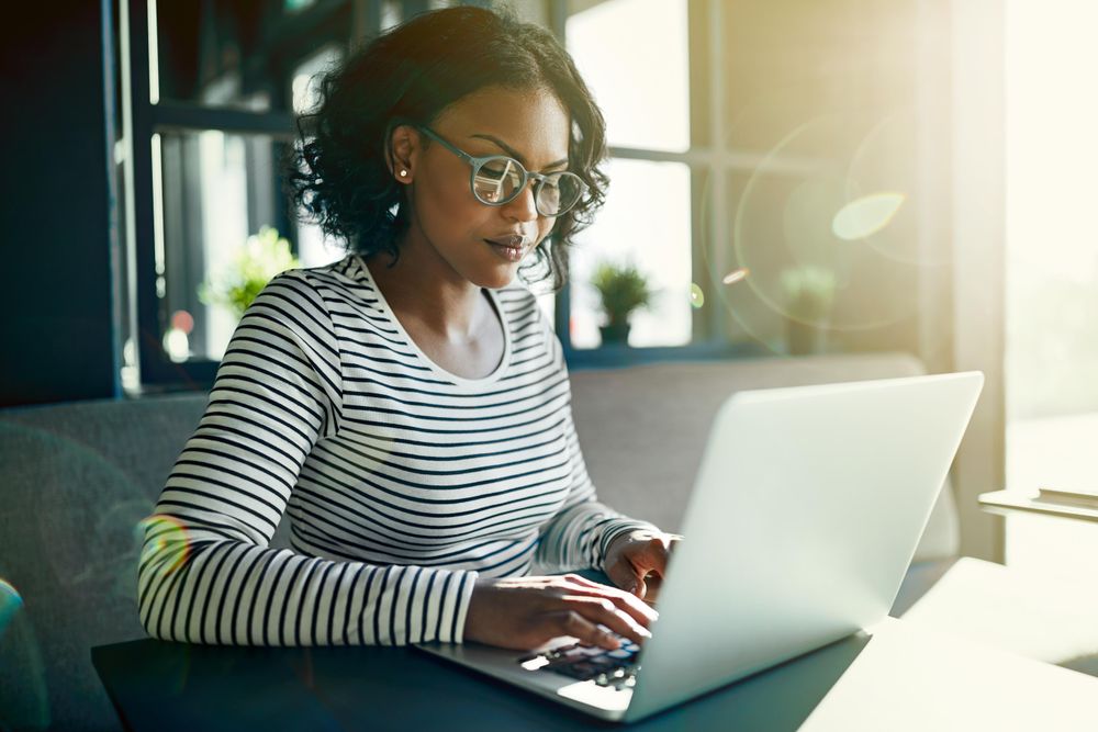 Focused woman working at laptop in cafe