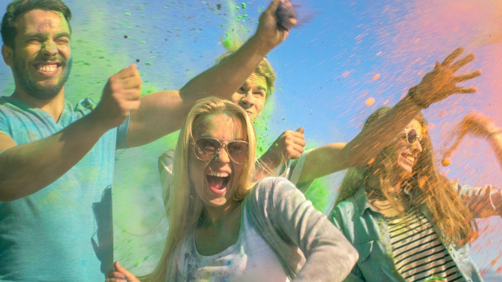 Multi-Ethnic Group of Young People Throw Colorful Powder in Celebration of Holi Festival.