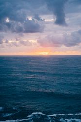 Grassy shore near stormy sea in evening