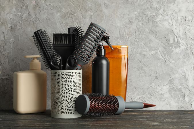 Composition with hairdresser accessories on wooden table, space for text