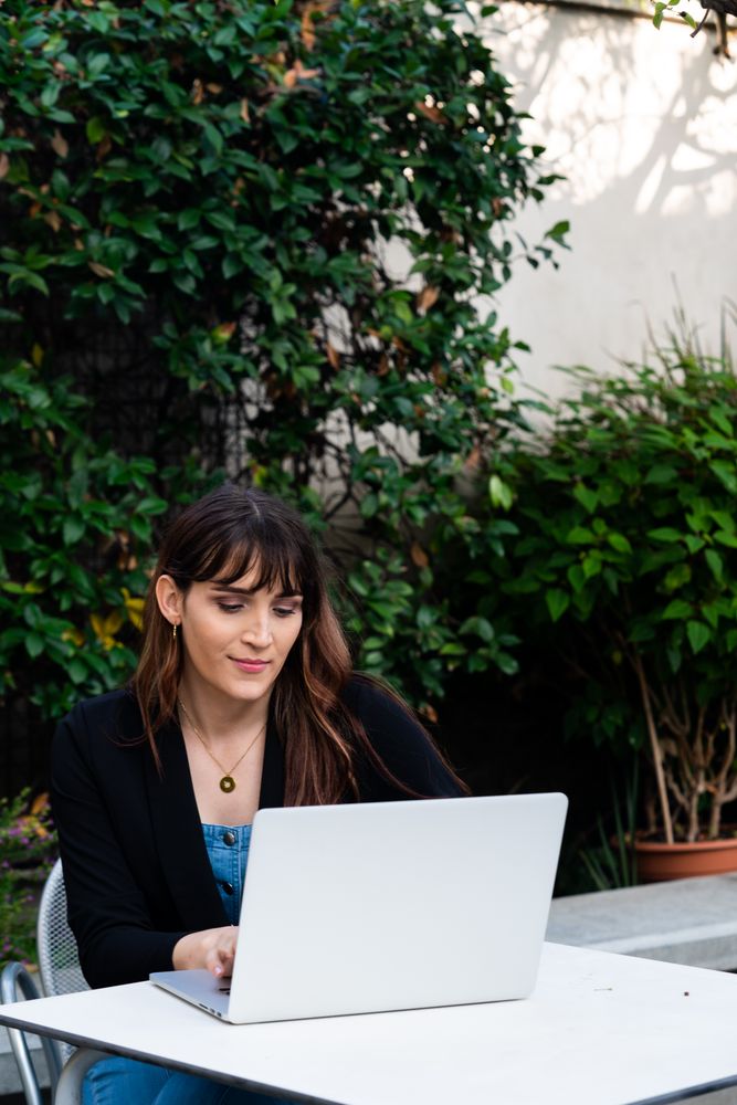Transgender woman typing on a laptop outside