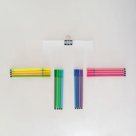 Arrangement of colorful pens with notepaper and copy space