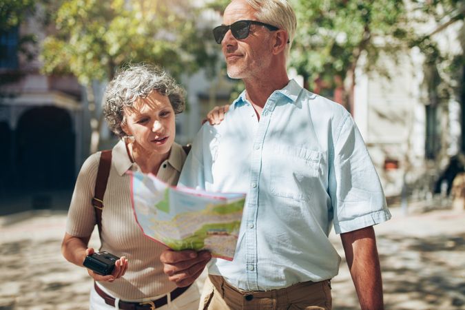 Mature couple using a map on a vacation with a map looking around
