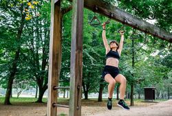 Woman doing monkey exercises on rings