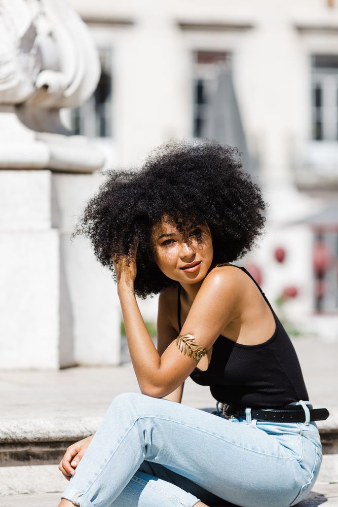 Black female sitting on stairs outdoors