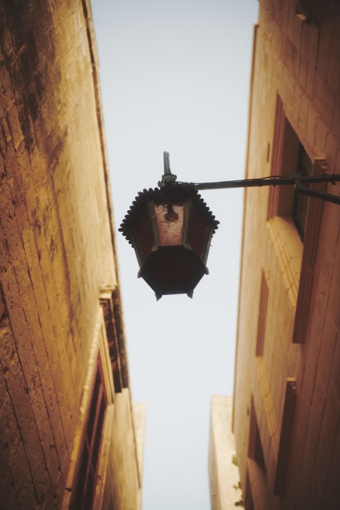 Looking up at beautiful lamp hanging in narrow lane