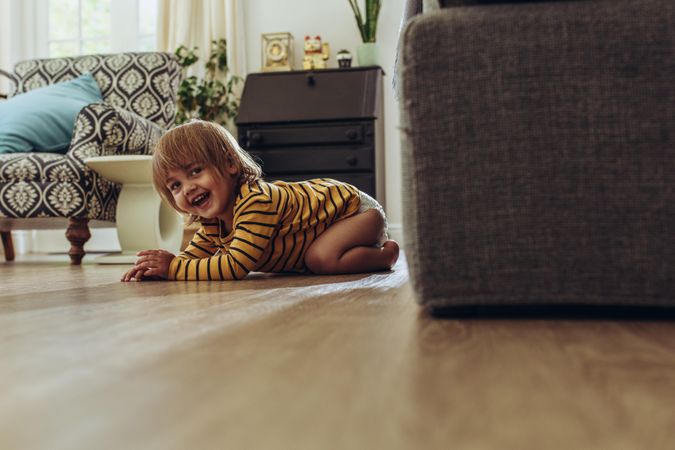 Smiling kid sitting on floor at home