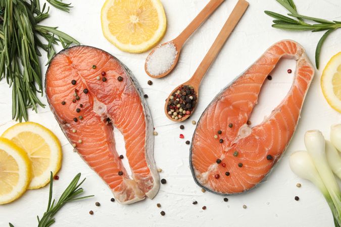 Composition with salmon meat and spices on light background, top view