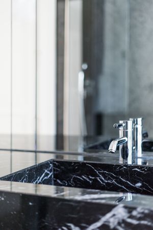 Marble sink and water tap in contemporary washroom