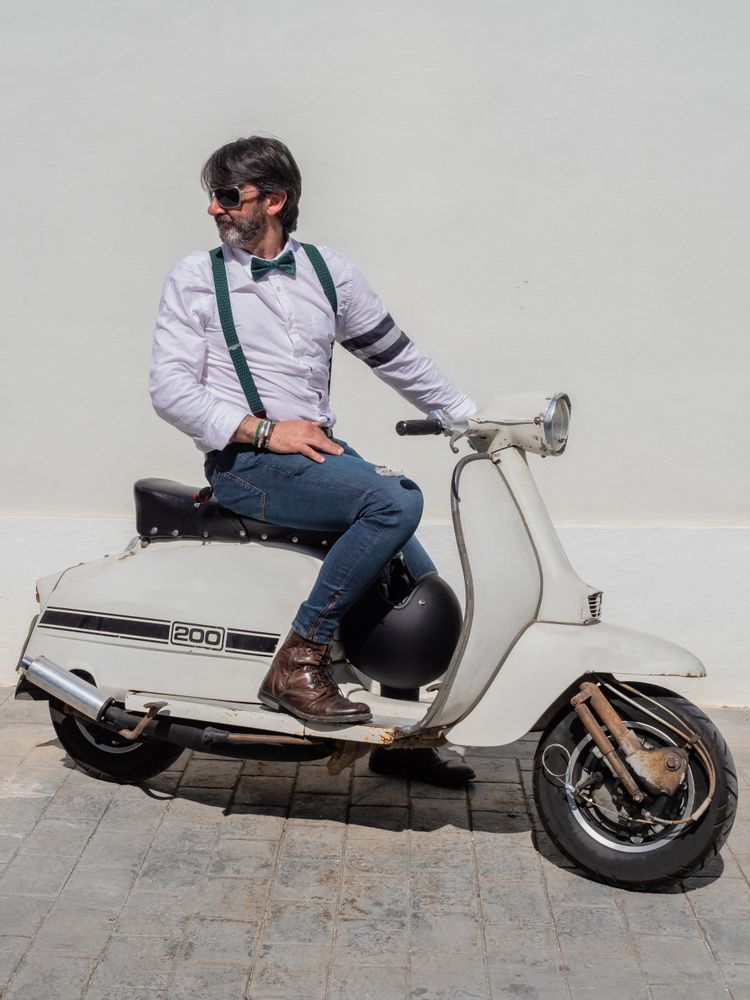 Trendy man sitting on vintage scooter