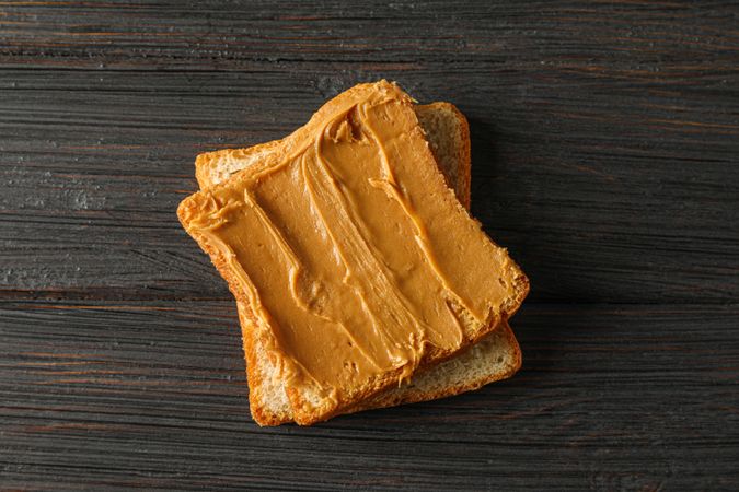 Peanut butter sandwich on wooden background, space for text and top view